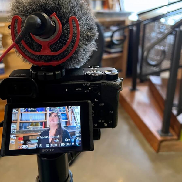 A video camera mounted on a tripod is positioned in front of an individual, ready for recording high-quality social content that showcases your brand’s authentic personality.
