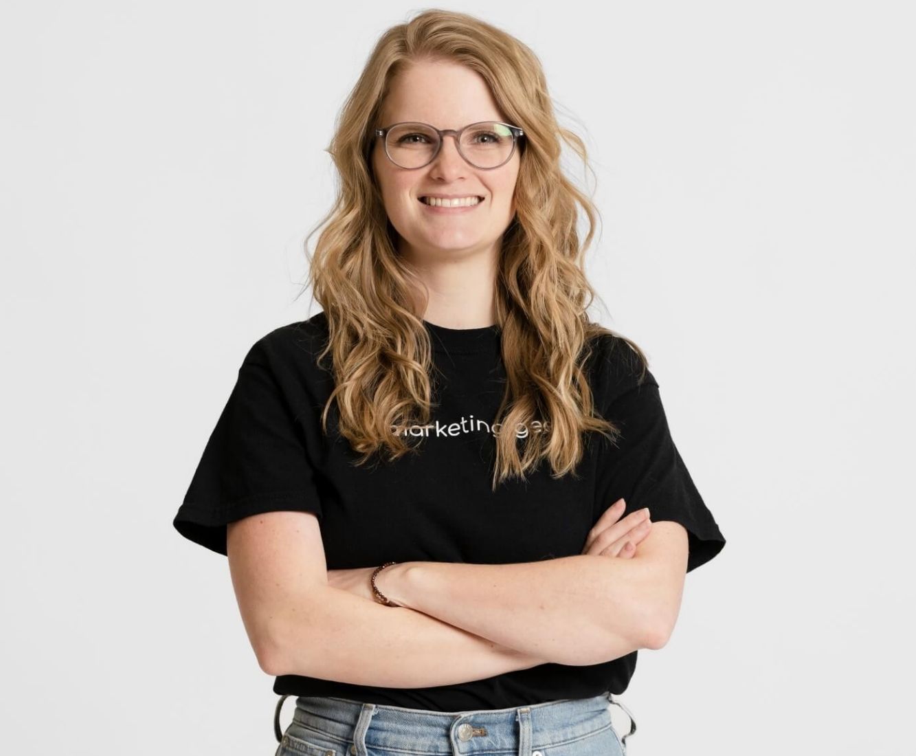 Kenzie Cundall Happiness Geek, stands proudly smiling in a black marketing geek t-shirt.