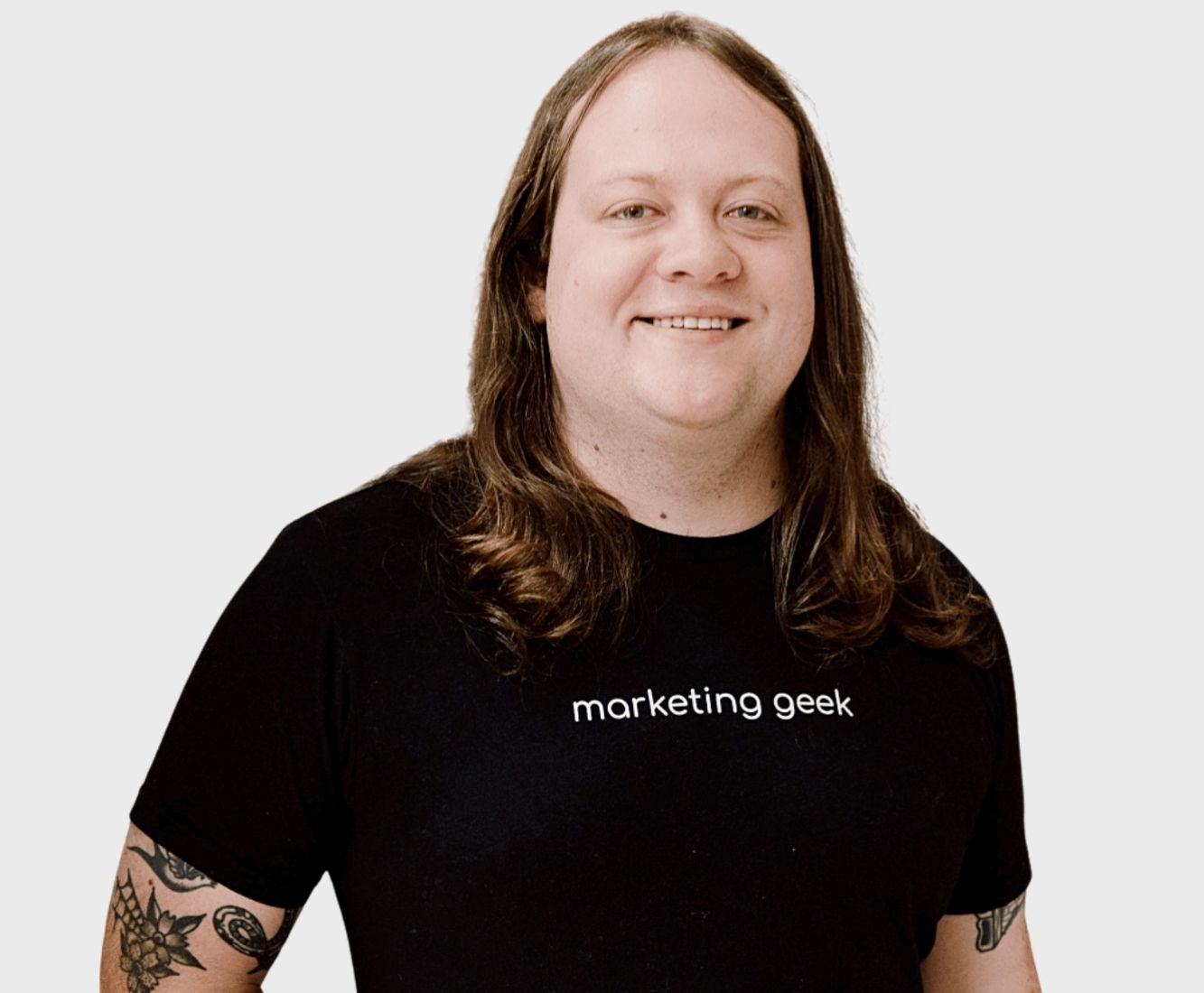 Kenzie Cundall Happiness Geek, stands proudly smiling in a black marketing geek t-shirt.