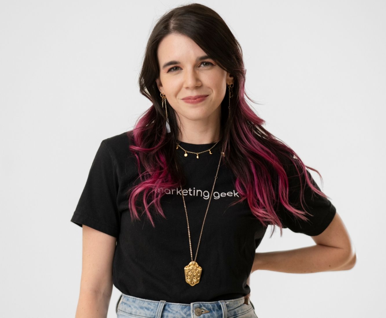 Kenzie Cundall Happiness Geek, stands proudly smiling in a black marketing geek t-shirt.