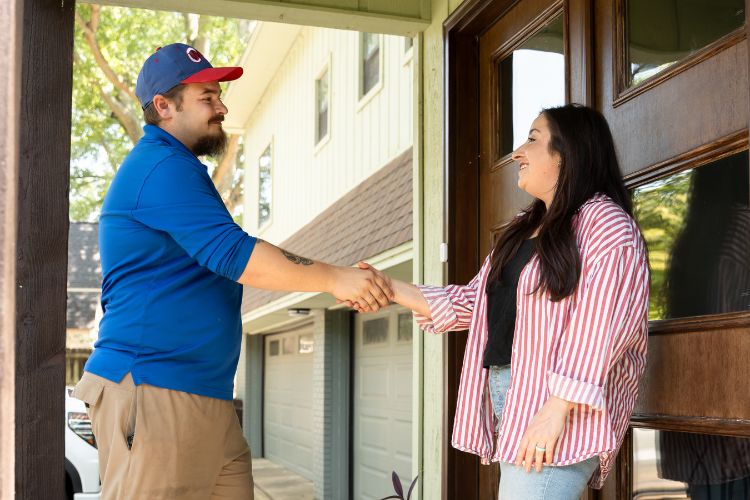 Two people laughing at work on laptops