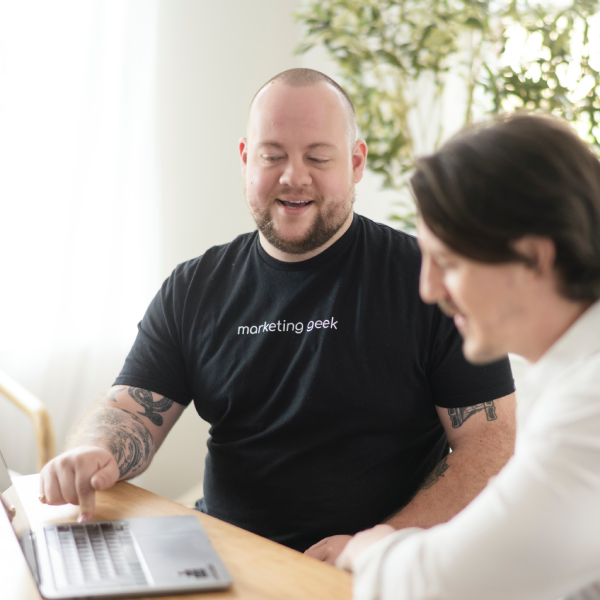 Nikki, the director of operations, smiles confidently in a black blazer and marketing geek shirt.